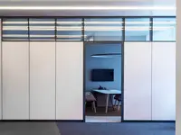 Vollwand-Systemtrennwand mit Oblicht und integrierter Tür für akustisch abgeschirmte Büro- und Fokusbereiche