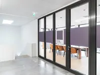 Brandschutz-Einscheibenverglasung EI30 mit integrierten Rahmentüren schafft transparente Schulungs- und Besprechungsbereiche mit geprüftem Feuerwiderstand