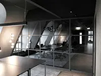 Ganzglas-Meetingraum im Loft-Stil bei quint-it mit filigranen Querstreben, transparenter Raumtrennung und hochwertiger Büroarchitektur