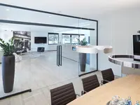 quint-it Einscheibenverglasung mit zweiflügeliger Ganzglas-Schiebetür und filigranen Profilen für transparente Besprechungsräume und moderne Büroarchitektur