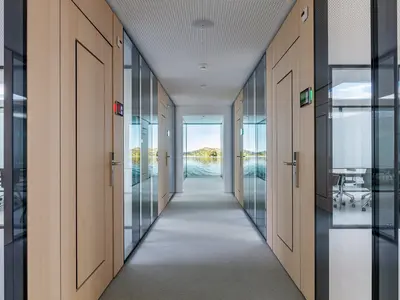 Geklebte Doppelverglasung von Uniska mit Echtholzfurnier und flächenbündig in die Türen integrierten Verbundlüftern bei der Ausgleichskasse Schwyz.