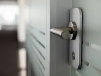 Detailaufnahme des Türgriffs einer Glastür im Doppelverglasungssystem bei Alpine Finanz Immobilien