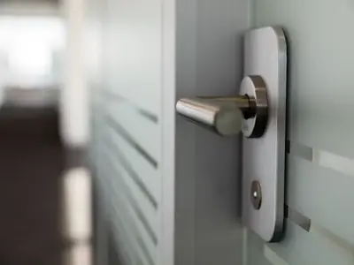 Detailaufnahme des Türgriffs einer Glastür im Doppelverglasungssystem bei Alpine Finanz Immobilien