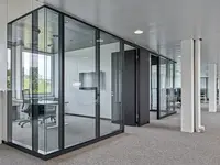 Büro- und Gemeinflächenausbau Georg Fischer AG in Schaffhausen: Grosszügige Glasflächen strukturieren die Arbeitsbereiche, ohne die offene Raumwirkung zu unterbrechen. Die filigrane Konstruktion mit dunklen Profilen schafft klare Raumgrenzen bei maximaler Transparenz und natürlichem Lichteinfall.