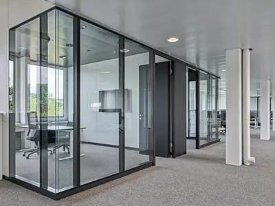 Büro- und Gemeinflächenausbau Georg Fischer AG in Schaffhausen: Grosszügige Glasflächen strukturieren die Arbeitsbereiche, ohne die offene Raumwirkung zu unterbrechen. Die filigrane Konstruktion mit dunklen Profilen schafft klare Raumgrenzen bei maximaler Transparenz und natürlichem Lichteinfall.