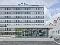 Büro- und Gemeinflächenausbau Georg Fischer AG in Schaffhausen: Die Aussenansicht zeigt das Zusammenspiel von bestehender Gebäudestruktur und zeitgemässer Erweiterung. Klare Linien, grosszügige Öffnungen und eine reduzierte Formensprache prägen den repräsentativen Auftritt des Standorts und geben einen ersten Eindruck der Architektur, die sich im Inneren konsequent fortsetzt.