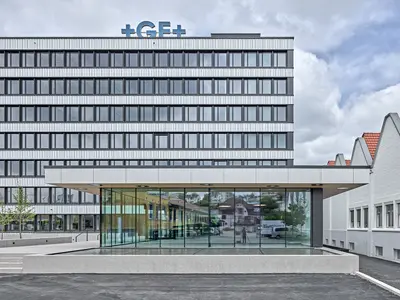 Büro- und Gemeinflächenausbau Georg Fischer AG in Schaffhausen: Die Aussenansicht zeigt das Zusammenspiel von bestehender Gebäudestruktur und zeitgemässer Erweiterung. Klare Linien, grosszügige Öffnungen und eine reduzierte Formensprache prägen den repräsentativen Auftritt des Standorts und geben einen ersten Eindruck der Architektur, die sich im Inneren konsequent fortsetzt.