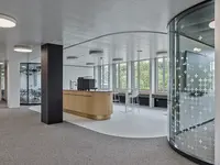 Büro- und Gemeinflächenausbau Georg Fischer AG in Schaffhausen: Die spezialgefertigte Structural-Glazing-Rundecke folgt der fliessenden Raumgeometrie und bildet einen nahezu nahtlosen Übergang im Glas. Präzise gebogen und passgenau integriert wird die Verglasung selbst zum architektonischen Gestaltungselement.
