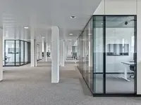 Büro- und Gemeinflächenausbau Georg Fischer AG in Schaffhausen: Grossflächige Structural-Glazing-Trennwände mit präzise ausgeführten 90°-Glasecken gliedern die Arbeitsbereiche, ohne die offene Raumwirkung zu unterbrechen. Die nahezu rahmenlosen Übergänge schaffen klare Sichtachsen und unterstreichen die geradlinige Architektur.
