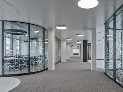 Büro- und Gemeinflächenausbau Georg Fischer AG in Schaffhausen: Spezialgefertigte Structural-Glazing-Rundecken führen die Glastrennwände fliessend durch die Büroflächen. Die präzise gebogenen Glaselemente verbinden Transparenz und anspruchsvolle Geometrie zu einer aussergewöhnlich leichten Raumarchitektur.