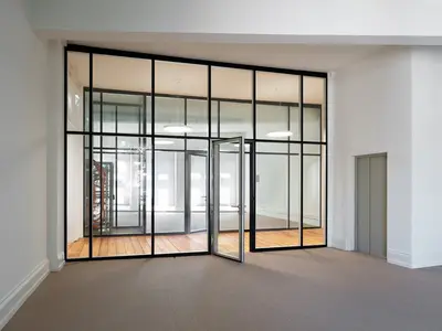 Büroumbau ICT Medien in Basel mit geklebter Doppelverglasung von UNISKA und filigranen schwarzen Profilen im historischen Bestand