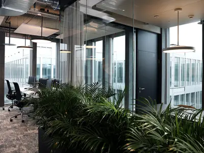 Rahmenlose Einscheibenverglasung mit schwarzen Profilen als transparente Trennwand im modernen Büroausbau von Inventx im Circle