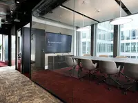 Von UNISKA realisierte Einscheibenverglasung mit schwarzen Profilen als filigrane Trennwand für einen Besprechungsraum im Neubau Inventx im Circle