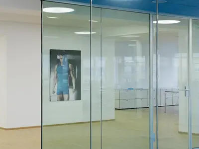 Raumhohe Einscheibenverglasung mit transparenter Glasecke und schlanken Profilen im Büro von Odlo International