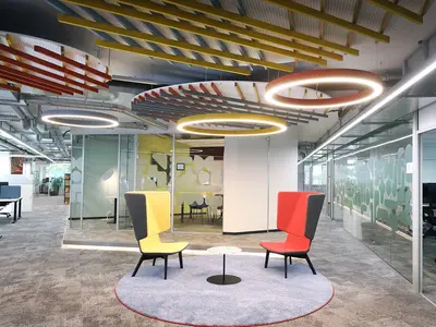 Modernes Office LAB Baslerpark in Zürich mit offenen Arbeitsbereichen, Glastrennwänden, farbigen Akustikelementen und kommunikativem Sitzbereich