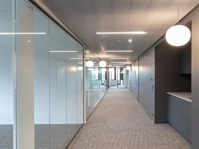 Einscheibenverglasung im Onyx-Gebäude in Baar. Die raumhohe Glastrennwand schafft transparente, lichtdurchflutete Bürobereiche und unterstreicht die klare, hochwertige Architektur.