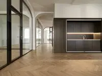 Massgefertigte Ganzglaswände von Uniska integrieren sich präzise in die historische Architektur an der Tödistrasse in Zürich. Doppelverglasung, gerundete Anschlüsse und filigrane schwarze Profile verbinden hohe Transparenz mit einer eleganten Raumgestaltung.