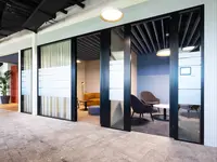 Büroumbau Visana Services AG in Bern: Die Glastrennwände formen klar definierte Rückzugs- und Kommunikationsräume innerhalb der offenen Coworking-Landschaft. Grosszügige Verglasungen erhalten die visuelle Verbindung zwischen den Bereichen, während Sichtschutz und Vorhänge je nach Nutzung unterschiedliche Grade an Privatheit ermöglichen. So entsteht ein wandelbares Raumkonzept zwischen Offenheit, Austausch und konzentriertem Arbeiten.