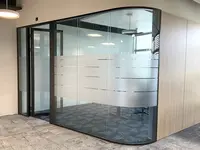 Ganzglaswand mit gerundeter Glasecke und integriertem Sichtschutz bei Visana in Bern.
