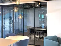 Besprechungsraum bei Klima AG in Spreitenbach: Die Einscheibenverglasung mit filigranen schwarzen Profilen und horizontalen Sprossen verbindet transparente Raumtrennung mit einem modernen Loft- und Industrial-Look.