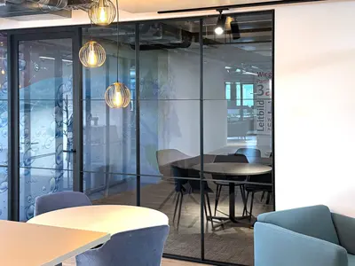 Besprechungsraum bei Klima AG in Spreitenbach: Die Einscheibenverglasung mit filigranen schwarzen Profilen und horizontalen Sprossen verbindet transparente Raumtrennung mit einem modernen Loft- und Industrial-Look.