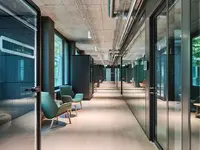 Raumhohe Ganzglaswände mit Doppelverglasung strukturieren den modernen Büroausbau in Emmenbrücke. Die transparenten Trennwände schaffen helle Sichtachsen und verbinden hohe Schalldämmung mit einer offenen, eleganten Raumwirkung.
