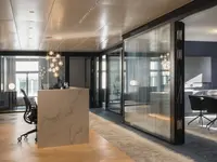 Hochwertiger Büroausbau mit raumhohen, doppelverglasten Ganzglaswänden und schwarzen Profilen. Die transparente Raumtrennung verbindet offene Architektur mit hohem Schallschutz und schafft ruhige, repräsentative Arbeits- und Besprechungsbereiche.