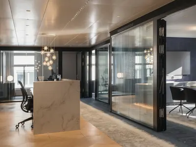 Hochwertiger Büroausbau mit raumhohen, doppelverglasten Ganzglaswänden und schwarzen Profilen. Die transparente Raumtrennung verbindet offene Architektur mit hohem Schallschutz und schafft ruhige, repräsentative Arbeits- und Besprechungsbereiche.