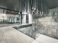 Neubau und Erweiterung Industriehalle Stoss in Walenstadt: Die grosszügige Glastrennwand fügt sich zurückhaltend in die hochwertige Innenarchitektur ein und bewahrt die offene, lichtdurchflutete Raumwirkung.