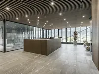 Neubau und Erweiterung Industriehalle Stoss in Walenstadt: Die grosszügige Glastrennwand fügt sich präzise in den repräsentativen Empfangsbereich ein und unterstützt die offene, klare Architektursprache.