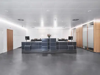 Geklebte Holz-Glas-Doppelverglasung von Uniska mit natürlichen Holzoberflächen im Empfangsbereich der Alpha RHEINTAL Bank AG.