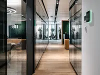 Durchgängige doppelverglaste Glastrennwände von Uniska strukturieren die Büro- und Besprechungsräume beim Umbau LLB Schweiz im Modissa Gebäude und schaffen transparente Verkehrswege.